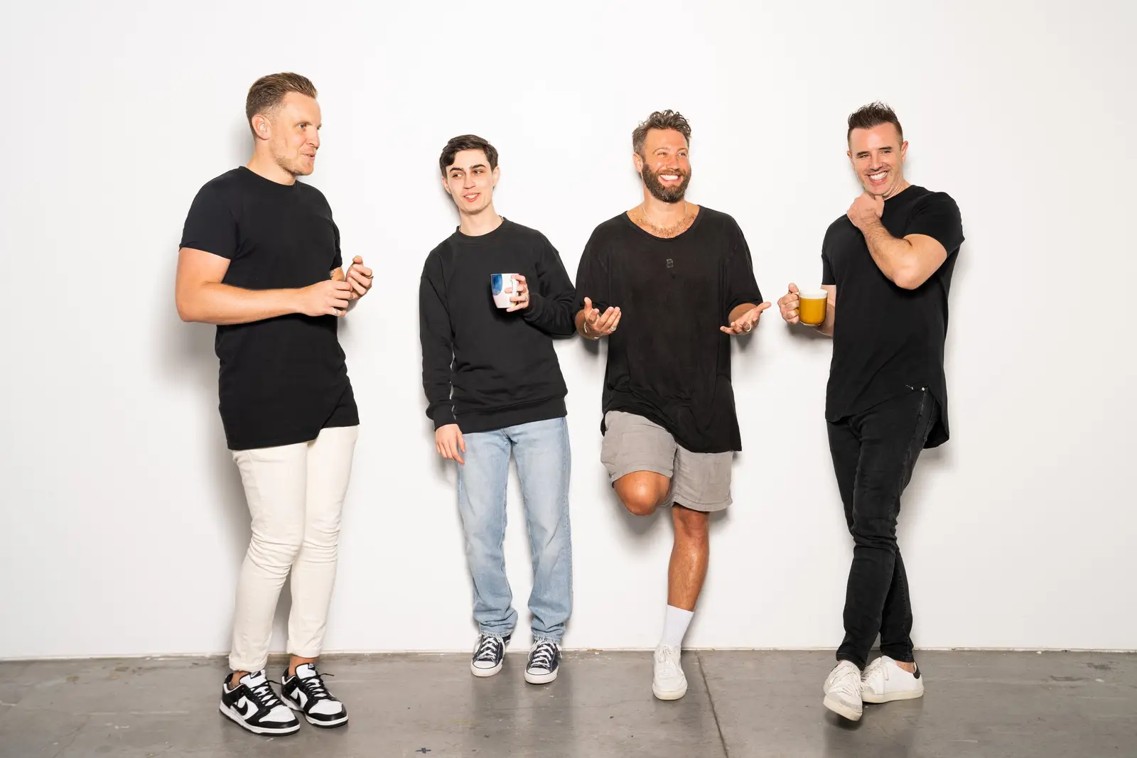 Four of the tekFinder team laughing together against a white studio wall